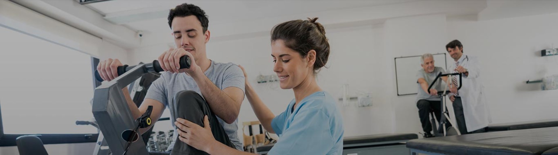 Occupational therapist helping patient on exercise bike