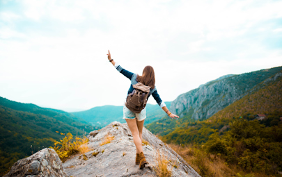 female traveler balances walking across mountain peak female traveler balances walking across mountain peak