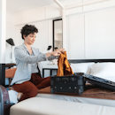 Woman folding clothes into suitcase Woman folding clothes into suitcase
