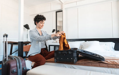 Woman folding clothes into suitcase Woman folding clothes into suitcase