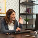 professional woman laughs while sitting at her desk  professional woman laughs while sitting at her desk